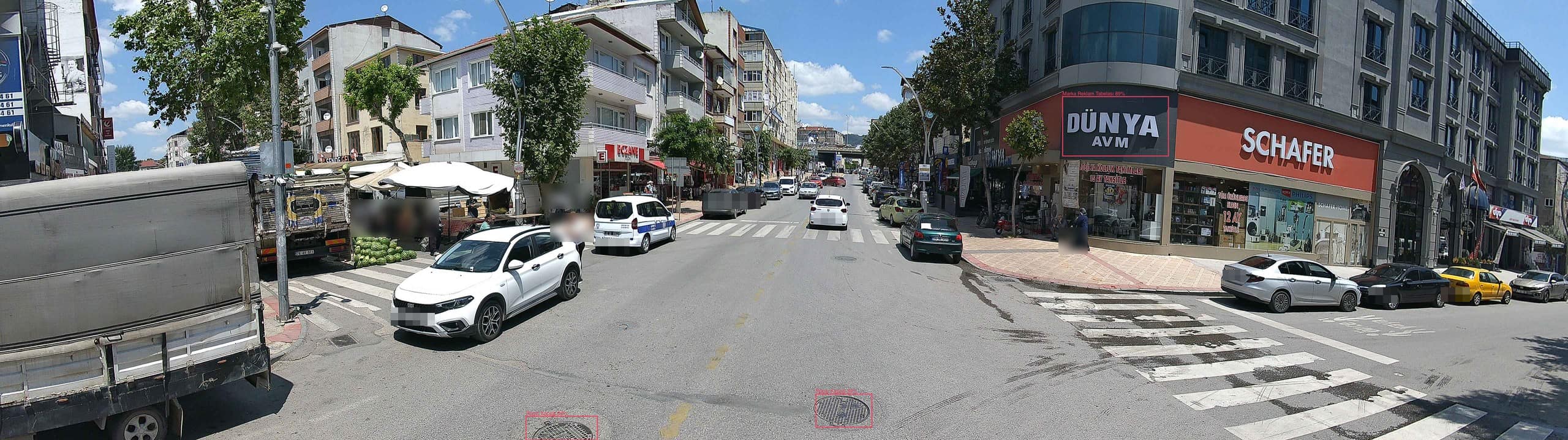 CityView araç kamerasından cadde görüntüsü: pazar tezgahı, rögar kapakları, reklam tabelası ve aşınmış yaya geçidi tespitleri